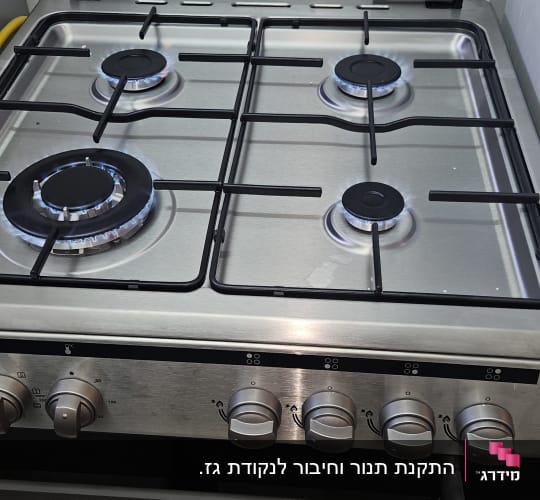 כיריים גז עם ארבעה מבערים דולקים